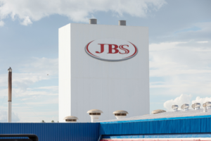 Foto de fábrica da JBS, com foco no logo