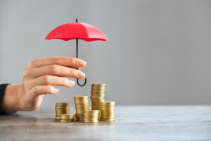 Pilhas de moedas sob um guada-chuva vermelha