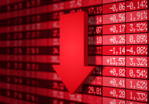 Imagem de seta vermelha para baixo à frente de gráfico de preços de mercados financeiros