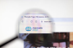 Lupa em computador apontando para o logo do Mercado Pago, em seu site