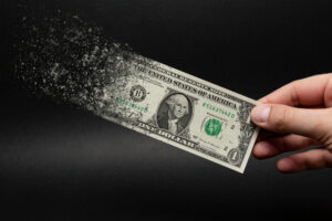 Nota de dólar sendo destruída pela inflação