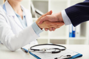 aperto de mão entre médica e homem de negócios